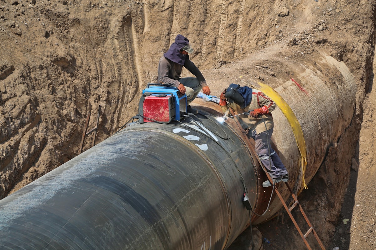 Technicians performing safety-focused maintenance on a pipeline